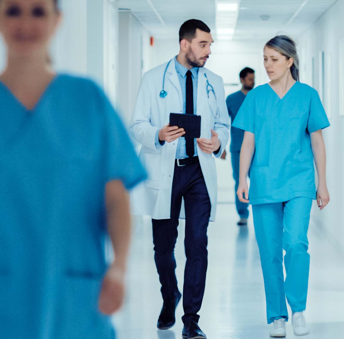 Medical colleagues discussing a case while walking down a hall